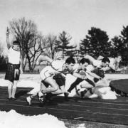 Jimmy Curran, wearing a kilt, starting a race at Mercersburg Academy