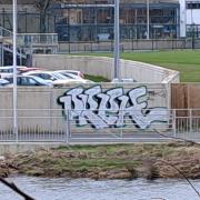 Graffiti has appeared on a section of Hawick's flood defence wall