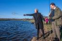 Watched by anglers including River Tweed Commission Chairman, Peter Straker-Smith (right), Mairi Gougeon MSP, Scottish Government Cabinet Secretary for Rural Affairs and Islands blesses the River Tweed with a dram of whisky as she officially opens the
