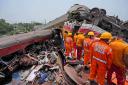 Rescuers work at the site of passenger trains that derailed in Balasore district (AP)