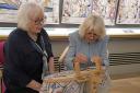 Great Tapestry of Scotland stitcher coordinator Dorie Wilke (left) watches Queen Camilla work on a commemorative tapestry during her visit to The Great Tapestry of Scotland visitor centre in Galashiels.