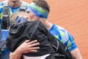 Kevin Sinfield kisses Rob Burrow as he carries him across the finish line of the 2023 Rob Burrow Leeds Marathon which started and finished at Headingley Stadium, Leeds. Picture date: Sunday May 14, 2023..