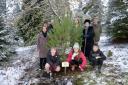 The planted Scot's Pine with from back left: Graham Stewart, Thomas Gifford, Fiona Woollard, Reverend Pamela Strachan, Tweeddale Lord Lieutenant Sir Hew Strachan, pupil Vincent's mum Alexia, Broughton Primary pupils: Vincent, Ruby and Angus.