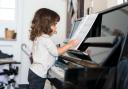 A young girl learning to play the piano