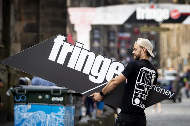 A man holding an Edinburgh Festival fringe sign. (Jane Barlow/PA)