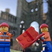 LEGO mini-figures ready to start building outside Kelso Abbey